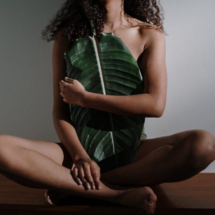 woman in green and white stripe dress sitting on brown wooden table