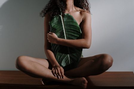 woman in green and white stripe dress sitting on brown wooden table